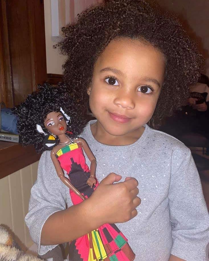 Girl Holding Diversity Doll by Ymma