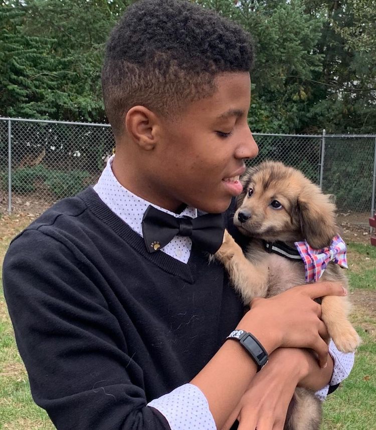 Sir Darius Brown Holding a Puppy Wearing a Bow Tie