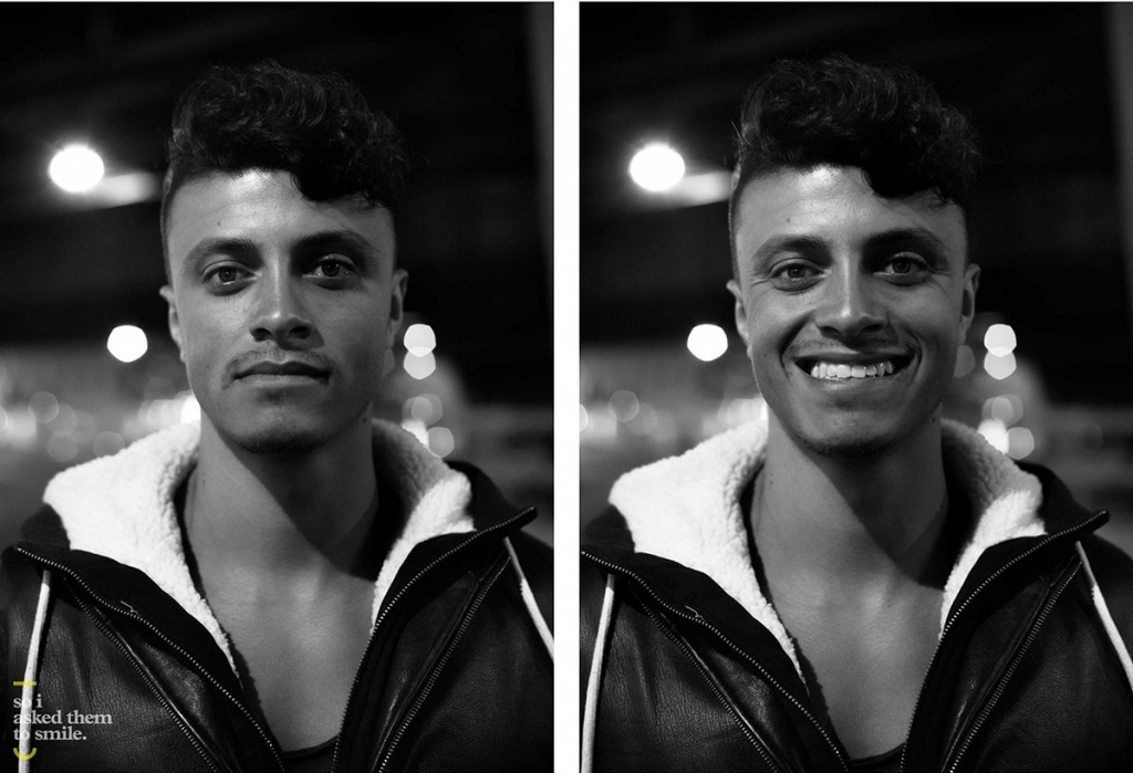 A young man stares, then smiles, at the camera in a black and white image