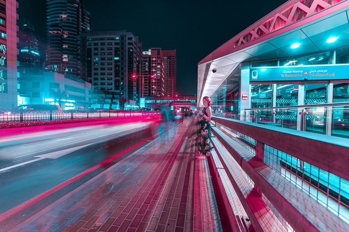 Woman Waiting for Public Transport in Dubai at Night