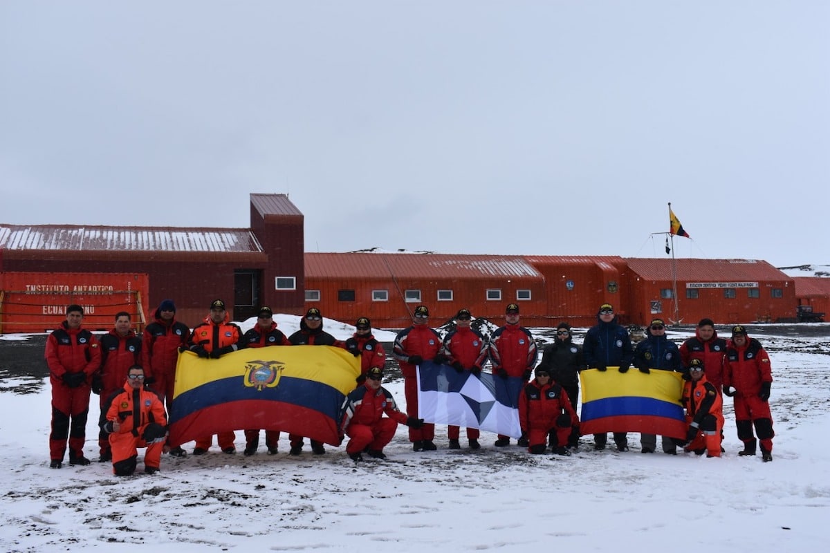 Members of Ecuador and Colombia's National Antarctic Programs with True South and their national flags at Maldonado Base, Antarctica