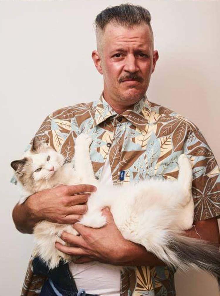 Man With Slicked Back Hair Holding a Cat
