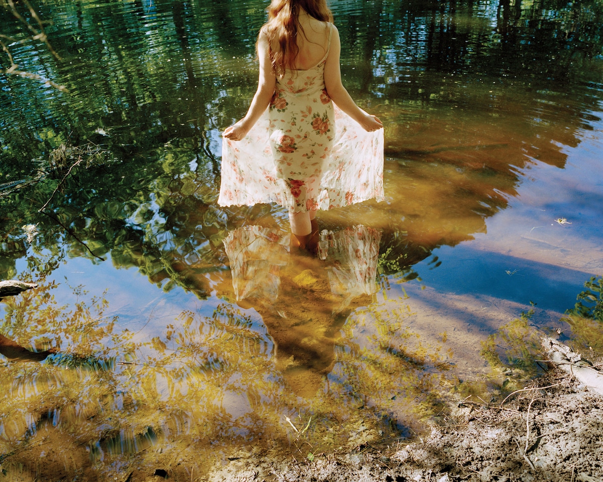 Photo of a Young Woman Wading into Water