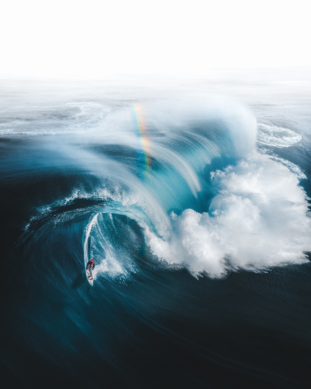 Surfer on Waves in Australia Under a Rainbow