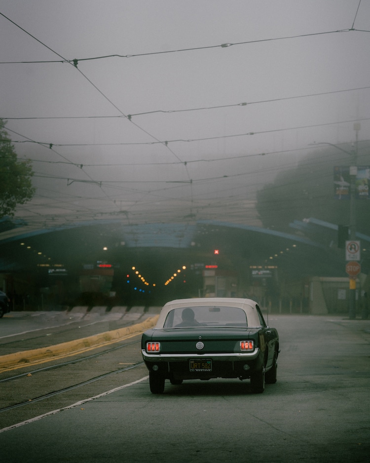 Classic Car Driving Down Foggy Street