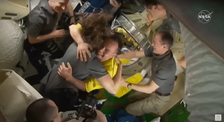 Russian Cosmonaut Hugging Colleague on the ISS