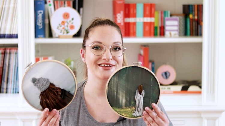 Floor Giebels Holding Up Two of Her Completed Embroideries