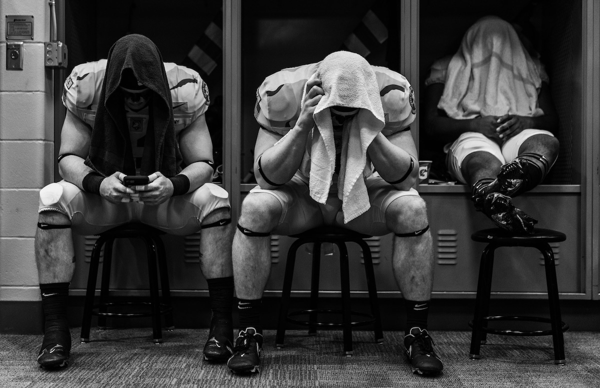 Football Players Sitting in a Locker Room