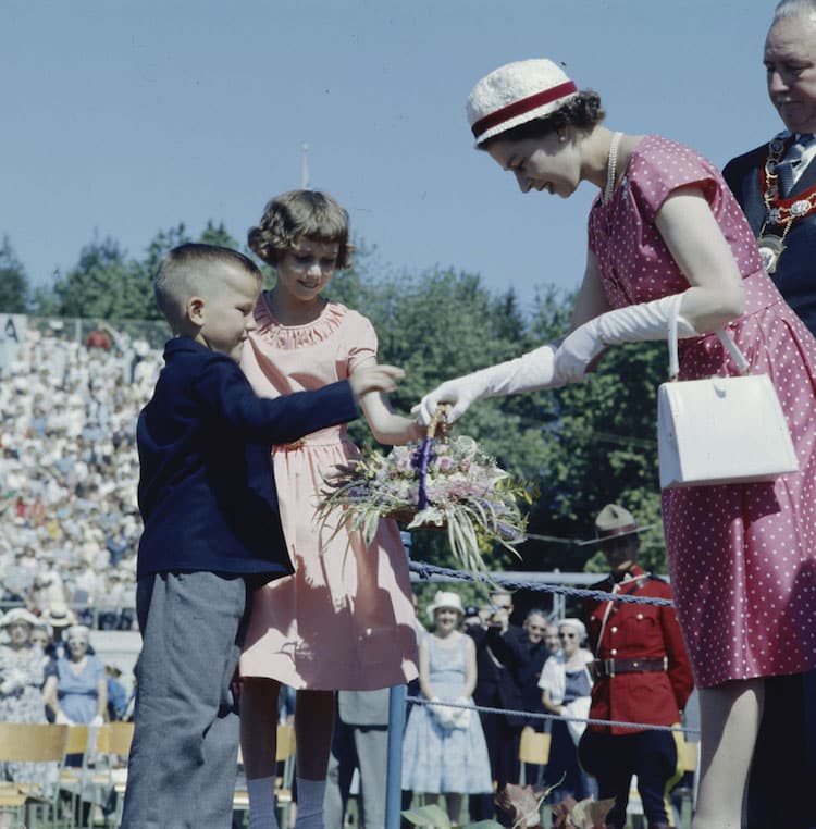 Queen Elizabeth II receiving bouquets of flowers from children in Ontario, Canada in 1959.