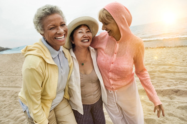 Middle aged friends smiling on the beach