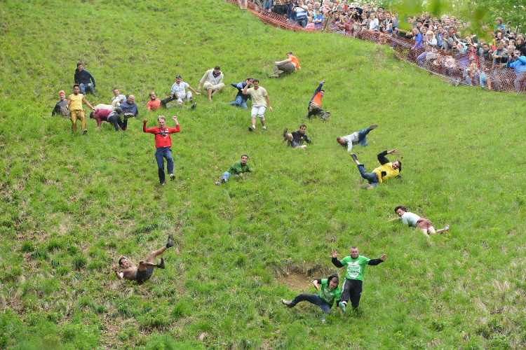 Runners tumbling down during rolling cheese race