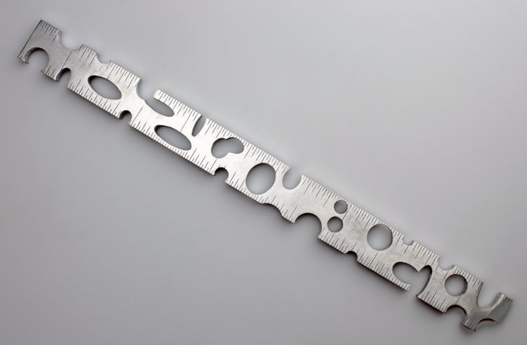 Ruler-shaped with holes, custom made metal measuring instrument by Rick Salafia
