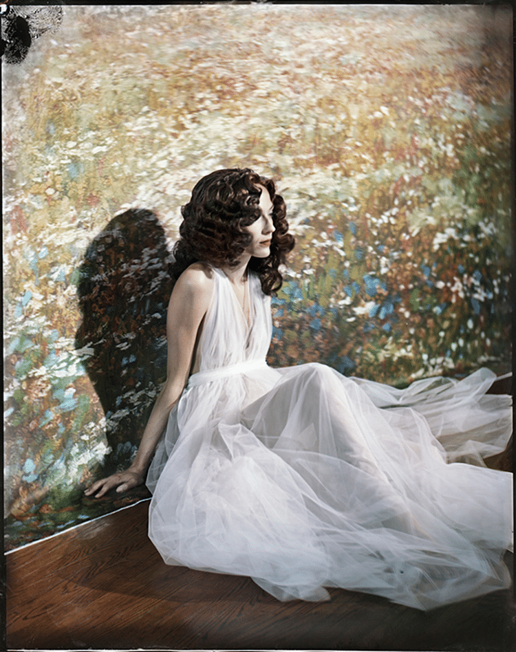 Woman in Flowy Dress Sitting Against Wall with Vintage Wallpaper