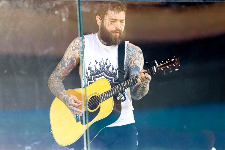 Post Malone Performing live on TSX Stage at Times Square. July 18, 2023, New York, USA: American rapper Austin Richard Post, known as Post Malone, is performing live at Times Square's TSX stage amidst severe weather with lots of fans crowding the Square .