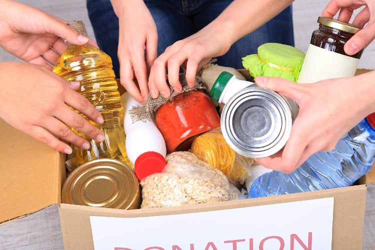 Food donation box with people putting items in it